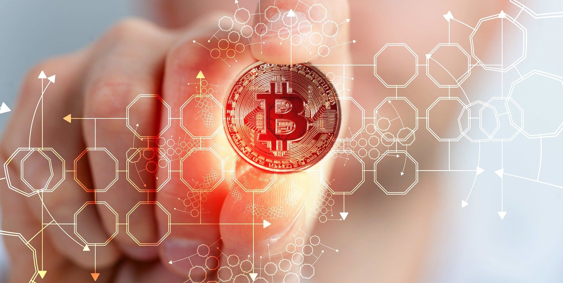 Dubai Company Setup  - A hand holding a red glowing Bitcoin with digital blockchain graphics overlay.