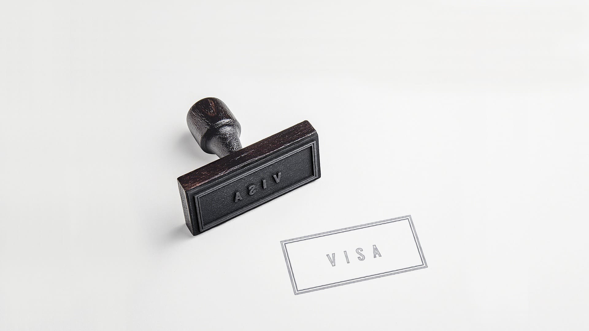 UAE business visa - Rubber stamp with 'VISA' imprint next to it on a white surface.